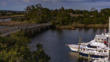 A marina with boats docked, a bridge crossing over water, and surrounding greenery.