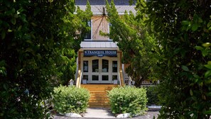 A wooden building labeled 'The Tranquil House Inn' with a sign above the entrance. - Tranquil House Inn (Manteo)