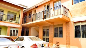 A two-story building with a balcony on the upper floor. - K-spot 1 Bedroom Flat Apartment (Kampala)