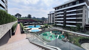 A residential building with a rooftop pool area featuring multiple swimming pools and a children's play area. - Modern Enaki Resort Apartment (Nairobi)