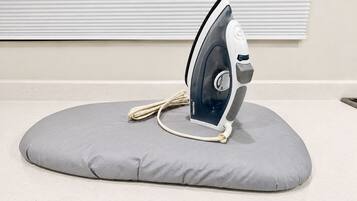 An iron on a gray cushion on a countertop.