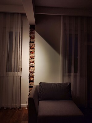 Relax in this serene space with a single bed and a brick accent wall, offering a calm atmosphere.