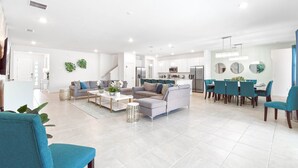 A spacious living area with a sofa, coffee table, and dining table set up. - Last Minute Disney! Private Pool, Hot Tub, Game Room & Themed Bedrooms. Book Now! #103381 (Orlando)