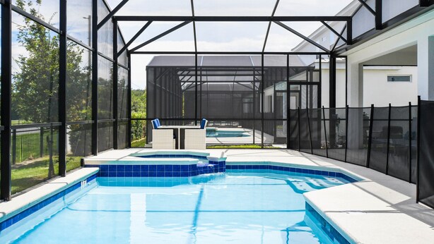 A swimming pool with a glass enclosure, a hot tub, and a covered seating area. - Last Minute Disney! Private Pool, Hot Tub, Game Room & Themed Bedrooms. Book Now! #103381 (Orlando)