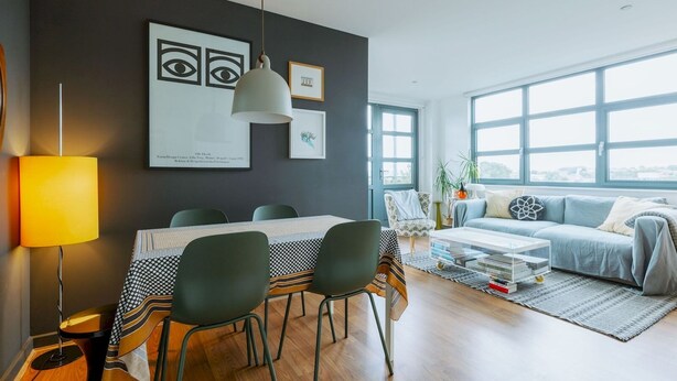 A modern living room with a dining area, large windows, and a view of the city. - Central Location Flat near Old St and Dalston Overlooking Rosemary Park and Regents Canal - Pass the Keys (London)