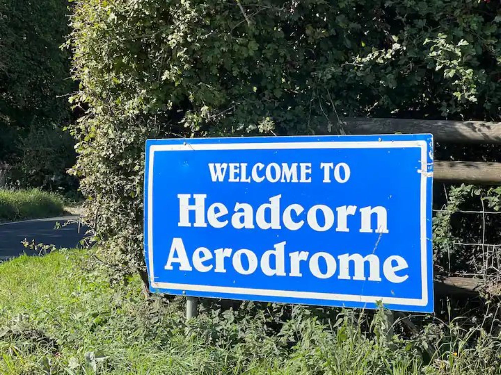 A blue welcome sign for Headcorn Aerodrome.
