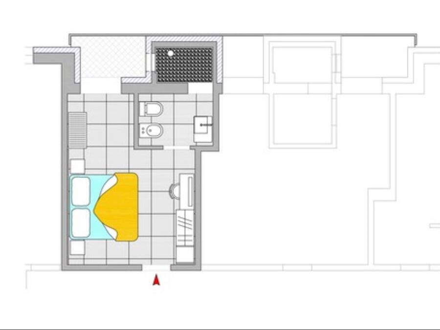 A floor plan of a hotel room with a bathroom, a kitchen area, and a living space with a sofa and a coffee table.