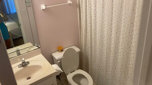 Un baño con inodoro, lavabo y espejo.
