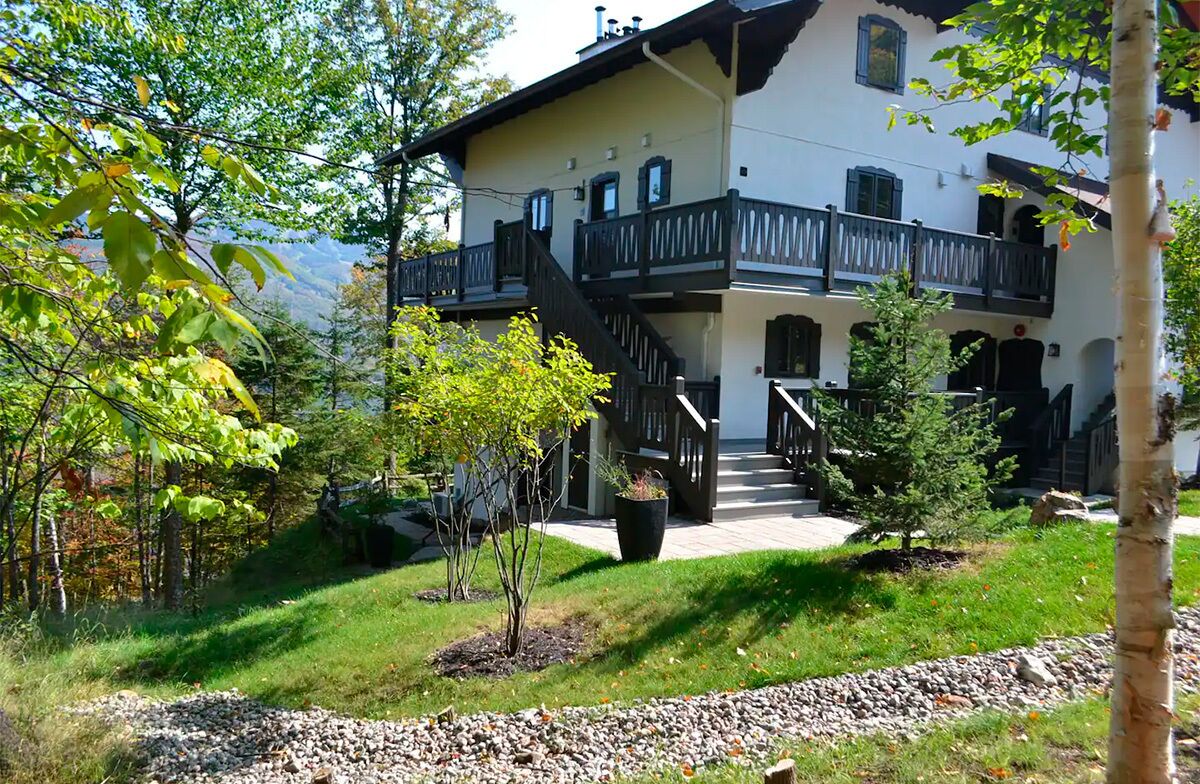 A two-story building with a balcony and a staircase leading to the entrance.