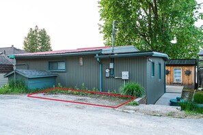 Un petit bâtiment d’un seul étage, avec un toit rouge et une enseigne portant le numéro « 213 ».