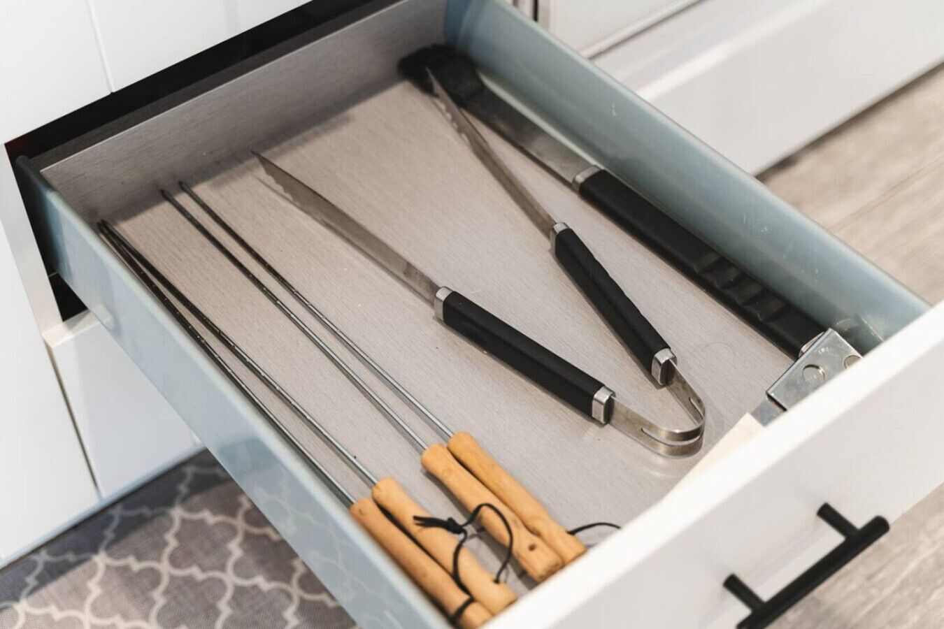 Eine Schublade mit Küchenutensilien, darunter Messer und eine Schere.