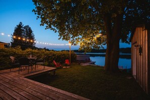 Une terrasse en bois avec des meubles d’extérieur, une petite table et des chaises.
