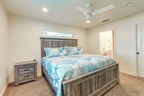 A bedroom with a wooden bed frame, a nightstand, a ceiling fan, and a window with a star decoration.