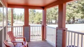 A covered outdoor area with wooden flooring and a railing. - Cozy Mountain Town Farmhouse for Winter Fun in Flag!  (Flagstaff)