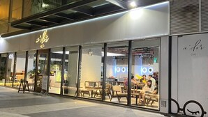 A cafe with outdoor seating, large windows, and a modern design.