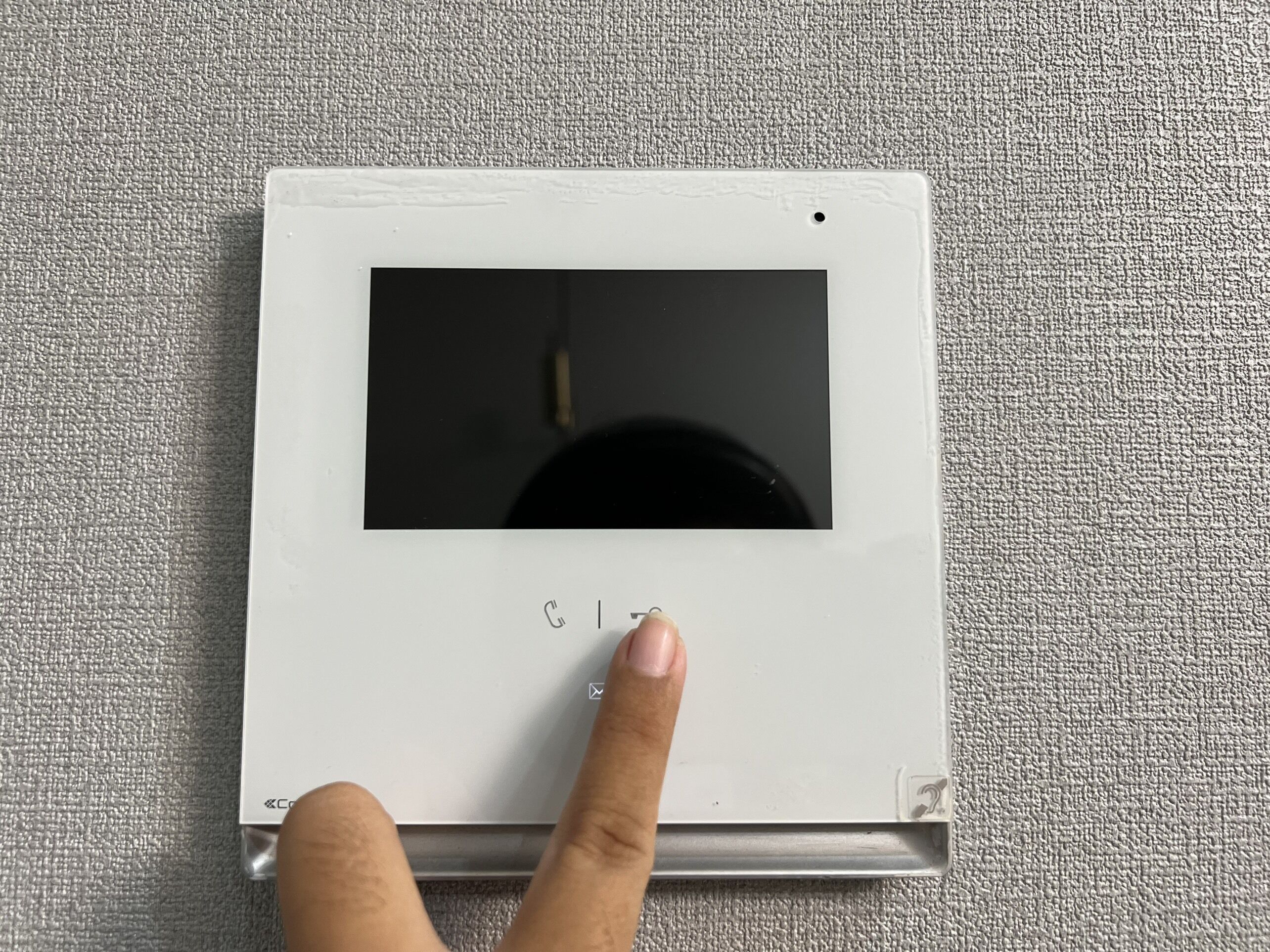 Ein Thermostat mit digitaler Anzeige und Bedienfeld, an einer strukturierten Wand angebracht.