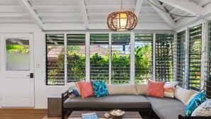 A modern living room with a large sectional sofa, a coffee table, and a hanging light fixture.