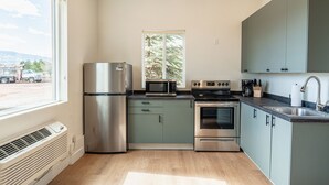 A modern kitchen with stainless steel appliances, a window, and a view of the outside. - Courtyard Casita - 2bed/2bath Inn (Torrey)
