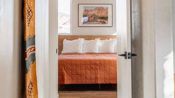 A bedroom with a bed, a window, and a painting on the wall. - Courtyard Casita - 2bed/2bath Inn (Torrey)