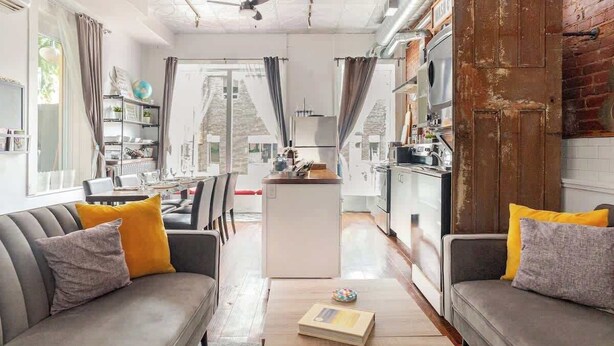Een moderne woonkamer met een bank, salontafel en uitzicht op de keuken.