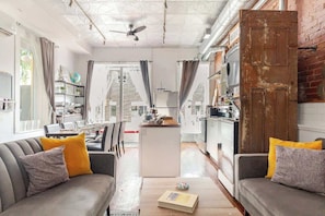 Una sala moderna con sofá, mesa de centro y vistas a la cocina.