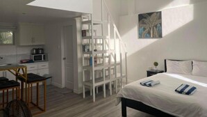 Une chambre à coucher avec un lit, une table de chevet et un tableau accroché au mur.