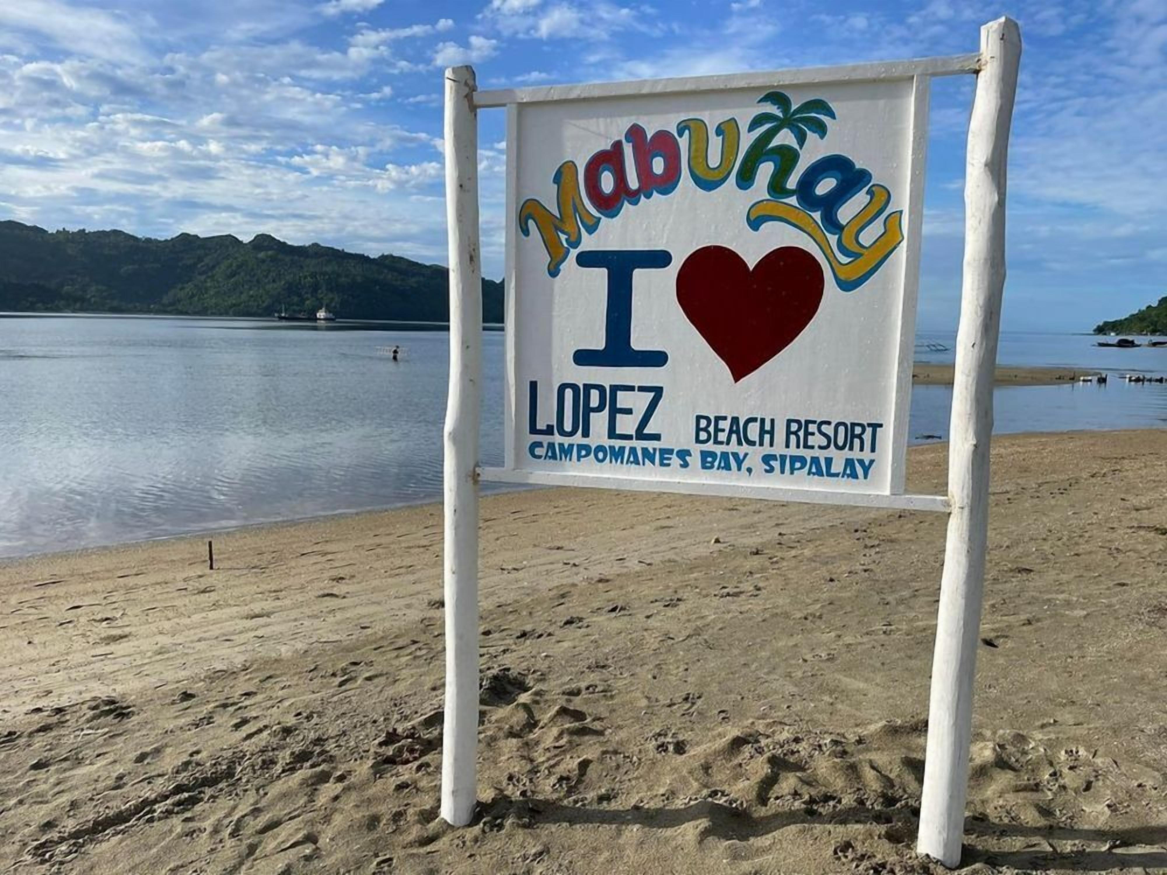 A beach sign with "Mabuhay I Love Lopez Beach Resort Campomanes Bay, Sipalay" written on it.