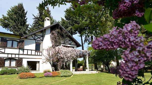Una casa de dos pisos con un jardín delantero.