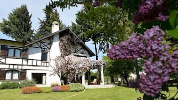 Uma casa de dois andares com um jardim na frente.