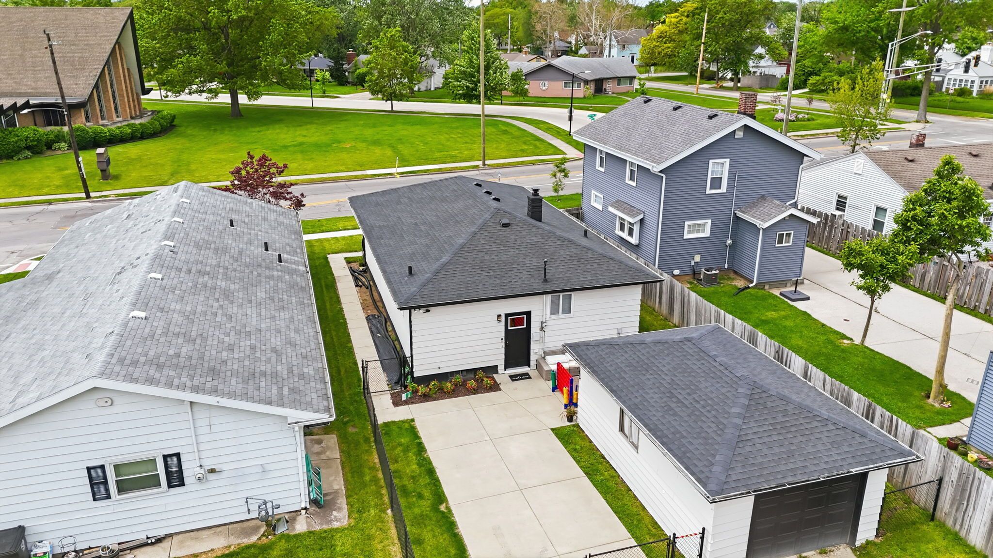 A residential area with houses, a driveway, and a lawn.