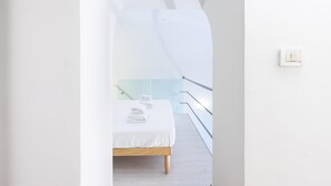 A modern hotel room with a bed, a small bedside table, and a window with a view of a balcony. - Venezia Double in Firenze (Florence)