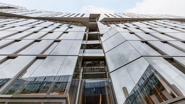A modern high-rise building with a reflective glass facade and a central atrium. - Battersea Power Station Flat With River Views (London)