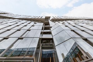 A modern high-rise building with a reflective glass facade and a central atrium.