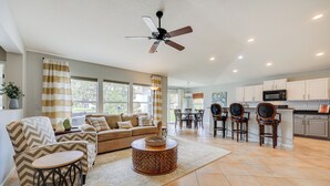 A spacious living room with a sofa, armchairs, a coffee table, and a dining area with chairs and a table. - Private Patio + Lake View: Fruit Cove Home (St. Johns)