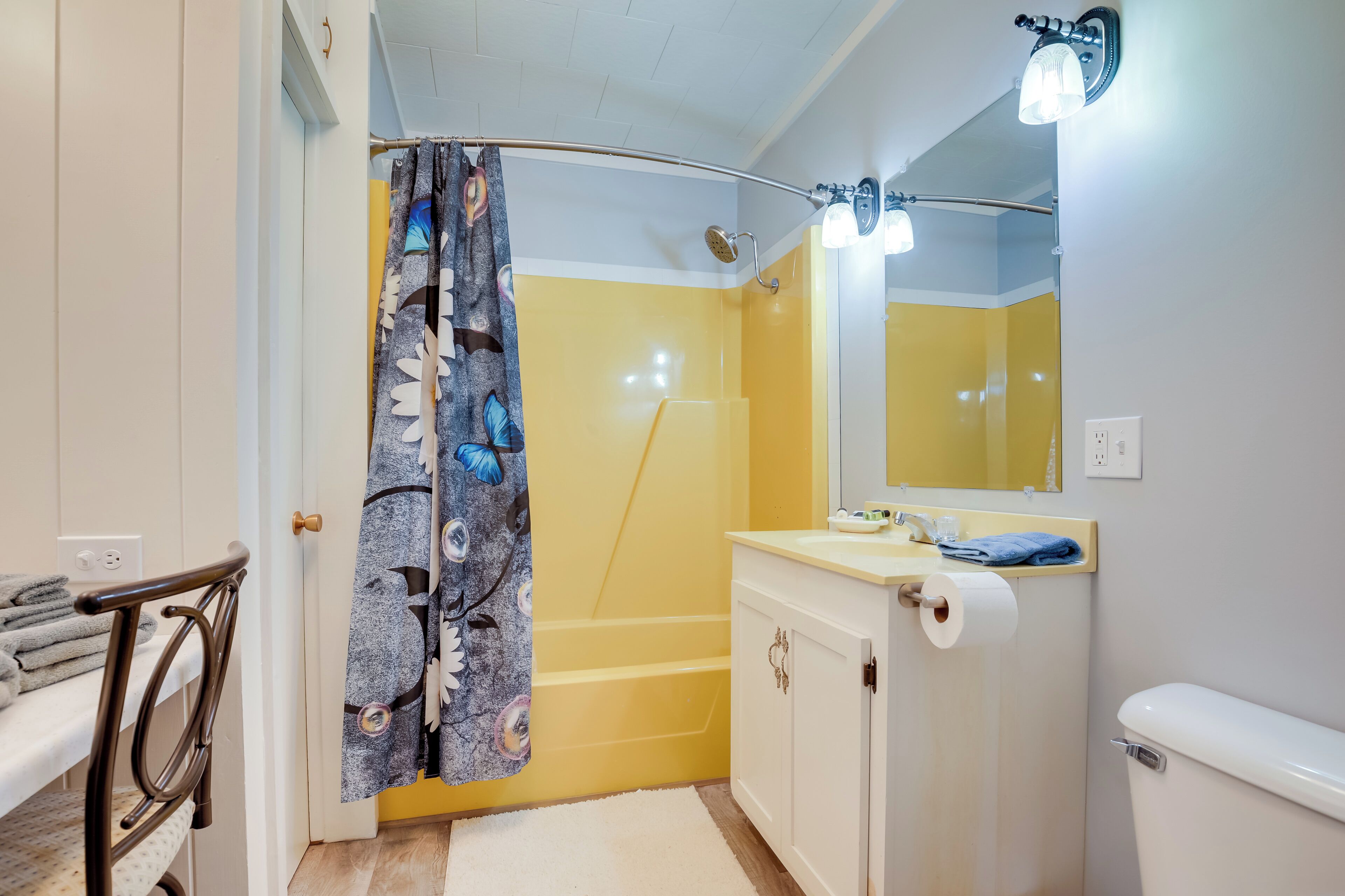 Ein Badezimmer mit Dusche, Toilette, Waschbecken und Spiegel.