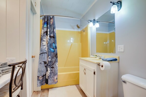 A bathroom with a shower, toilet, sink, and a mirror. - Peaceful Saint Germain Home w/ Fire Pit! (St Germain)
