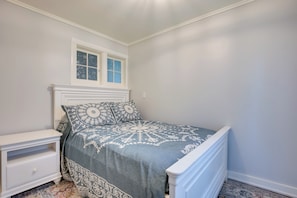 A bedroom with a bed, a nightstand, a window, and a patterned rug. - Peaceful Saint Germain Home w/ Fire Pit! (St Germain)