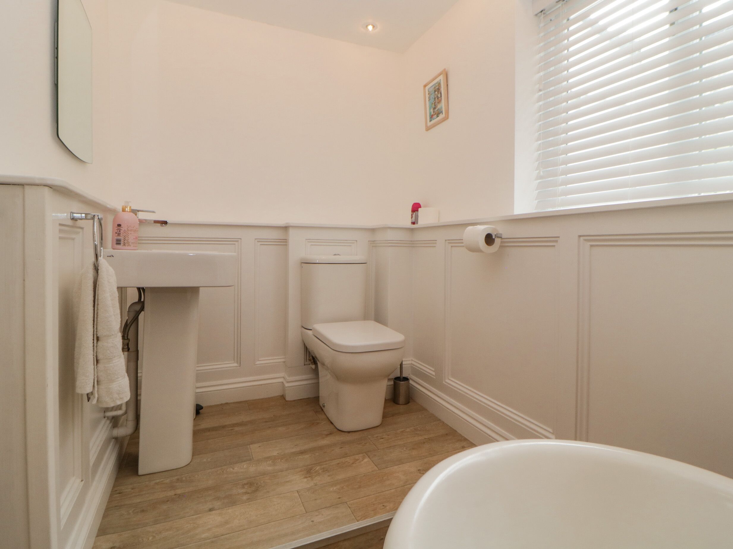 A bathroom with a toilet, sink, and bathtub.