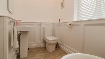 A bathroom with a toilet, sink, and bathtub.