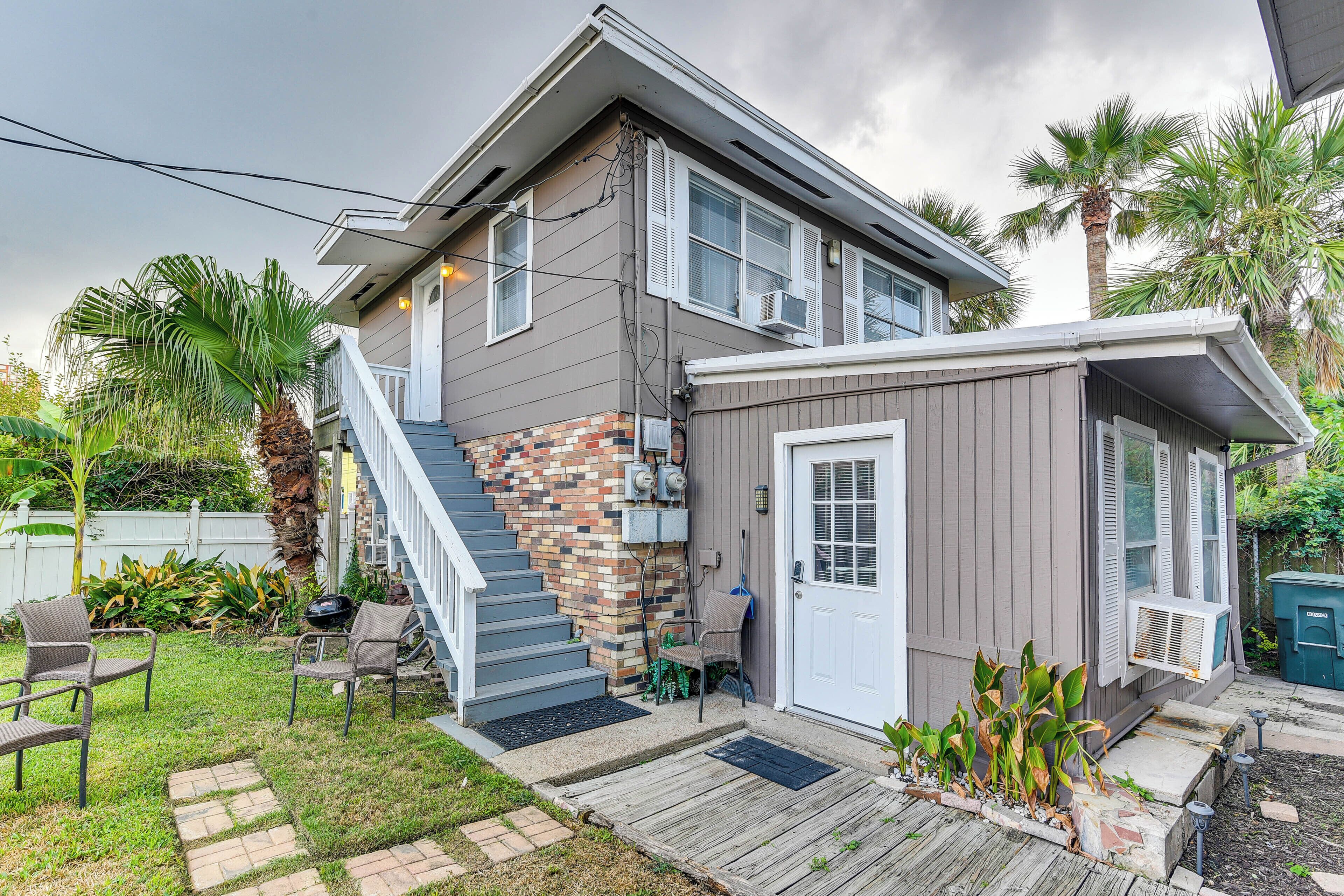 A two-story house with a covered porch, a small attached garage, and a backyard with a patio and outdoor seating.