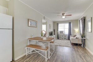 A modern kitchen with white cabinetry, a wooden dining table, and a ceiling fan. - ~ 1 Mi to the Strand: Central Unit in Galveston! (Galveston)