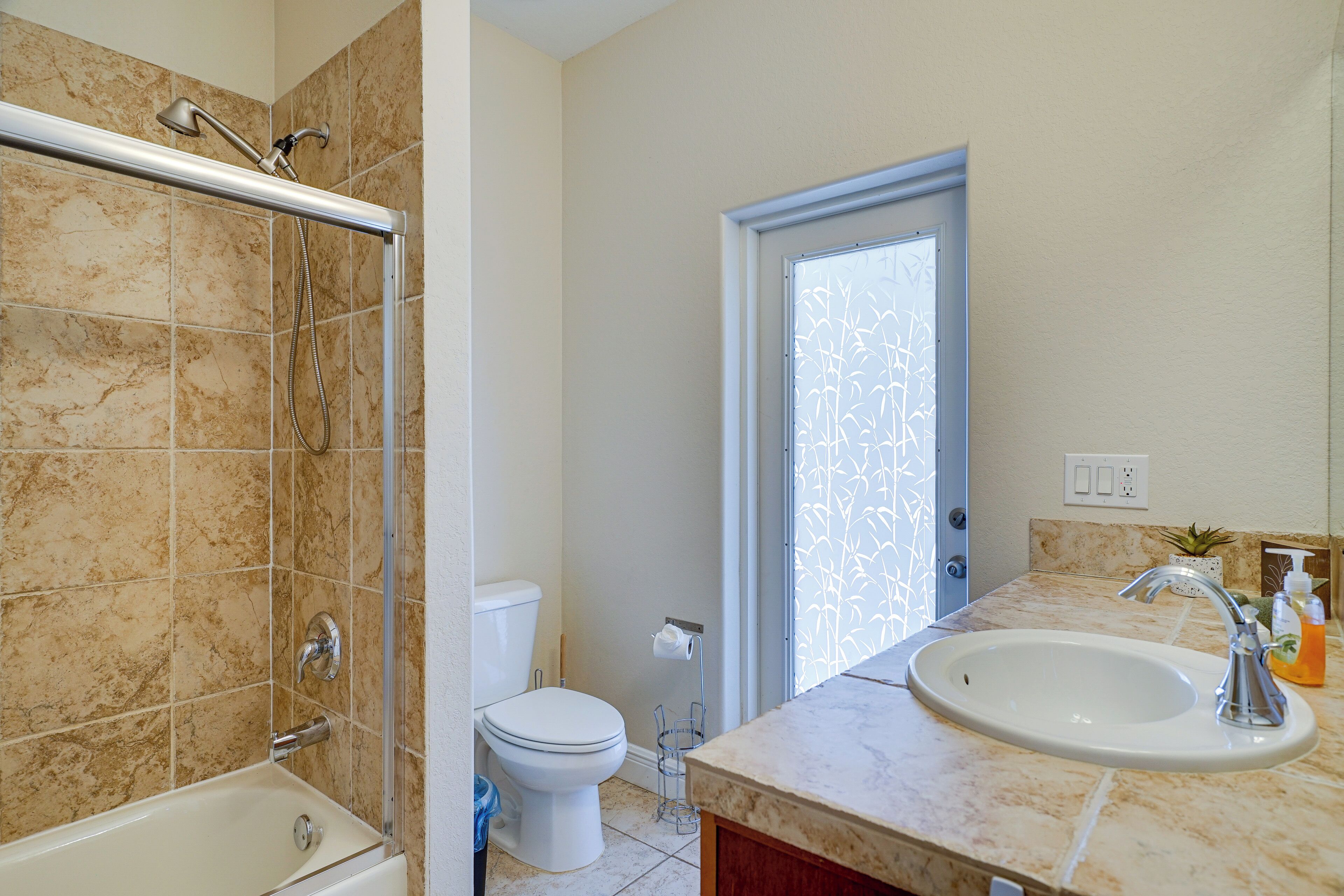 A bathroom with a bathtub, toilet, and sink.