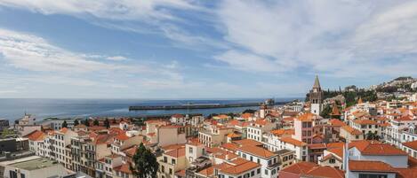 A coastal cityscape with historic buildings and a prominent tower.