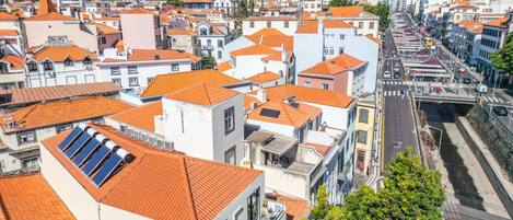 Un paysage urbain présentant une variété de bâtiments, notamment des immeubles résidentiels et commerciaux, tous coiffés de toits recouverts de tuiles rouges.