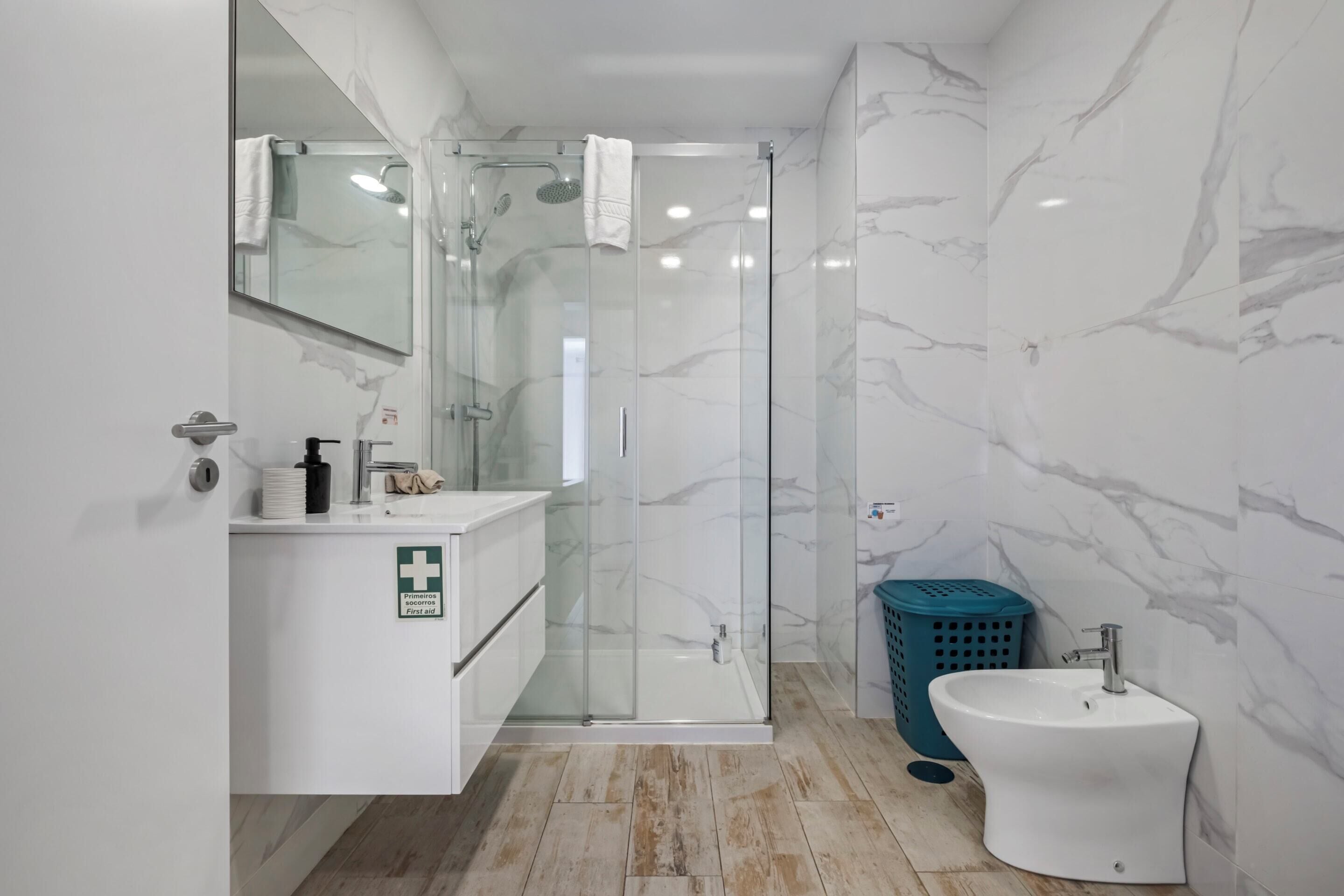 Une salle de bain moderne avec une douche à parois de verre, un lavabo et un miroir.