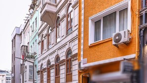 Una calle con edificios de varios pisos, algunos con balcones y unidades de aire acondicionado.