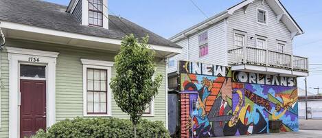 A building with a green facade and a mural on the side.