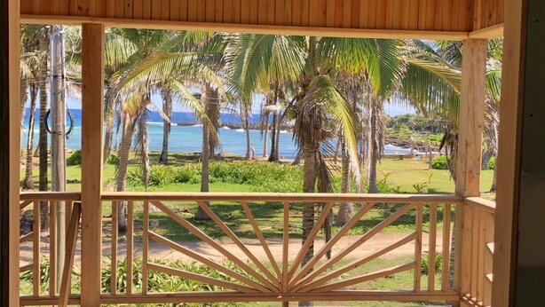 A wooden deck with a view of the ocean and palm trees. - Spacious 2 or 3 BR ocean side home with pool - private lot & panoramic views. (Utila)