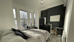 Une chambre à coucher avec un grand lit, un bureau et une armoire.
