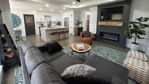Una sala de estar moderna con un sofá gris, una mesa de centro y una chimenea.
